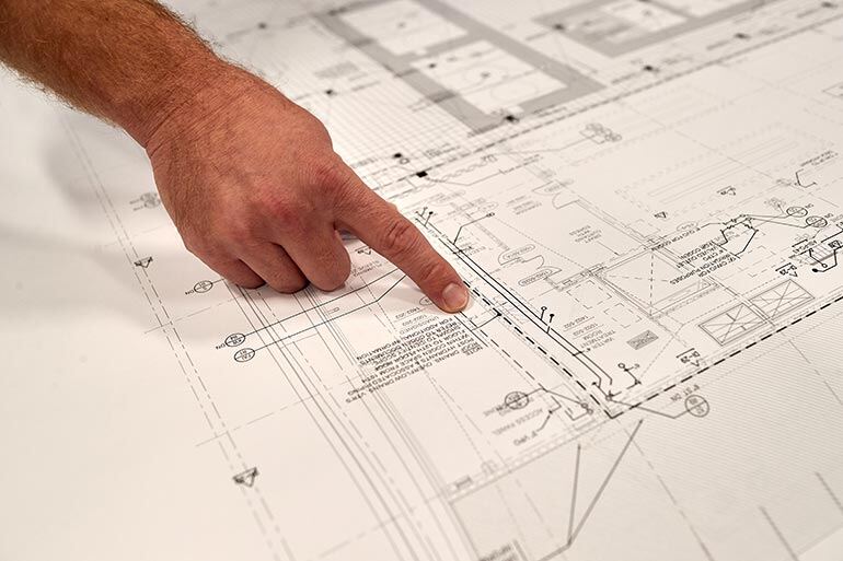 man-pointing-to-building-plans